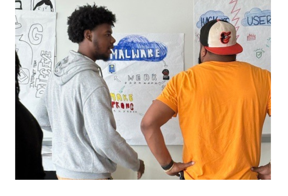 A male student showing teacher a cyber project